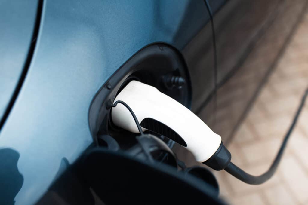 An electric car charging at home station. Close-up view of plug-in.